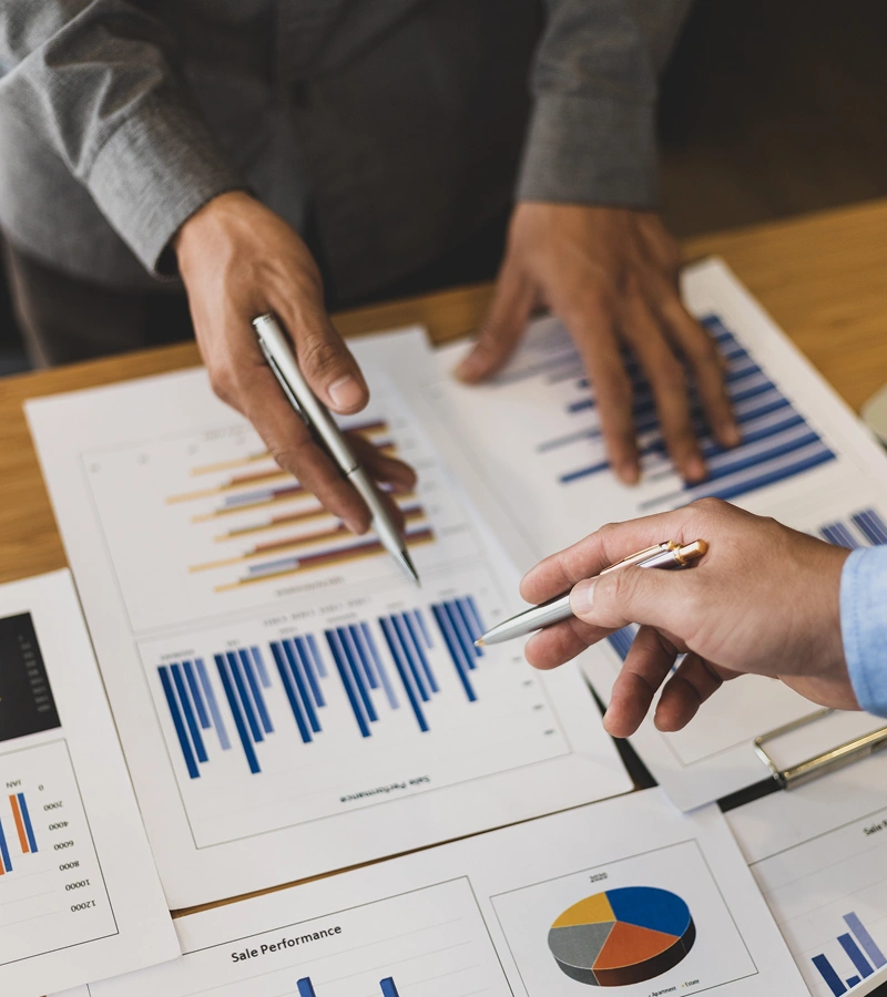 People analyzing printed business charts and graphs.