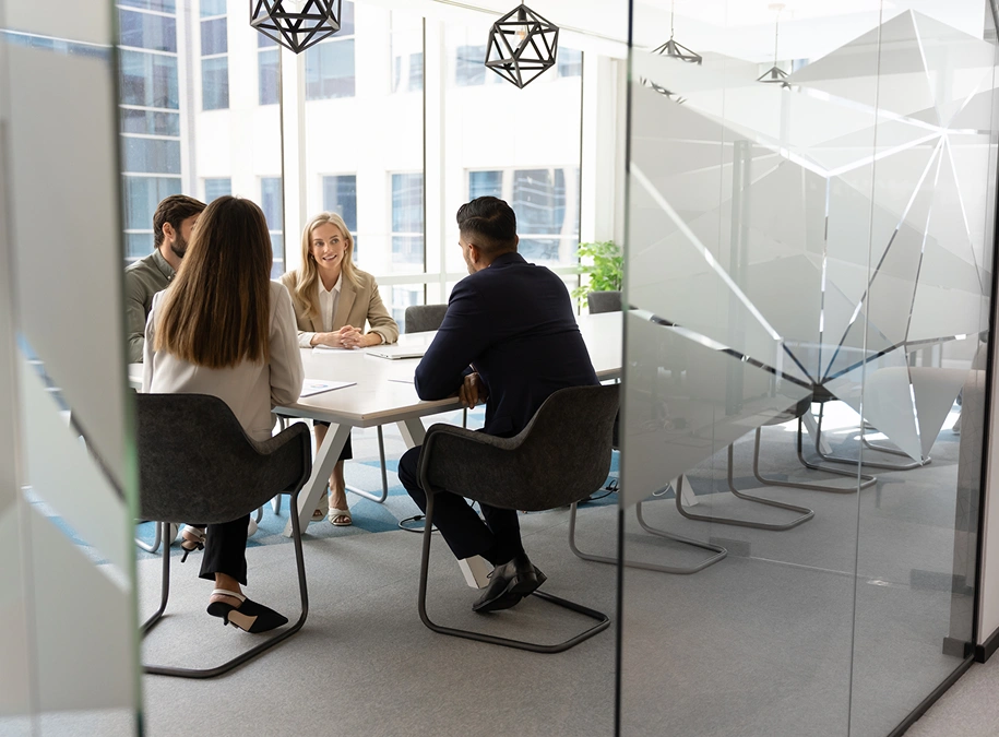 Meeting in a modern glass-walled office.